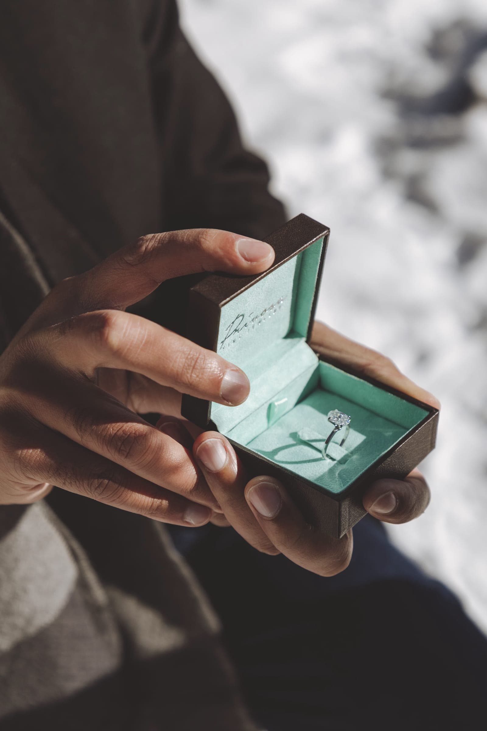 A Privosa solitaire engagement ring held open in its box